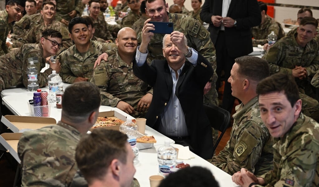 President Biden maakt vrijdag een selfie met Amerikaanse militairen die in Polen zijn gelegerd, op 100 kilometer van de grens met Oekraïne, ter versterking van de oostflank van de Navo. (beeld afp / Brendan Smialowski)
