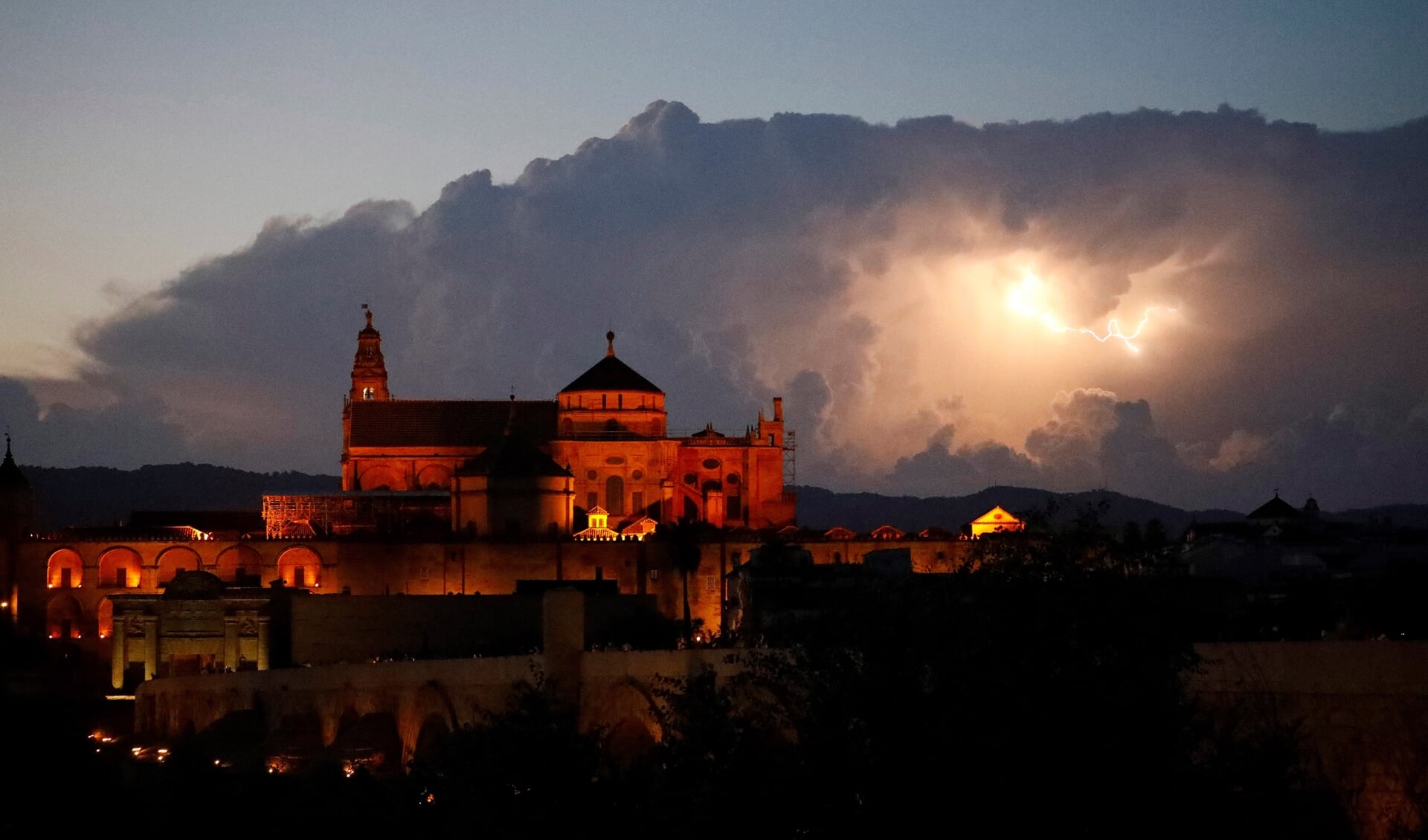 De lucht boven de moskee-kathedraal in Córdoba licht op door onweer. Met welk recht heeft de Katholieke Kerk dit cultureel erfgoed als haar eigendom laten inschrijven?