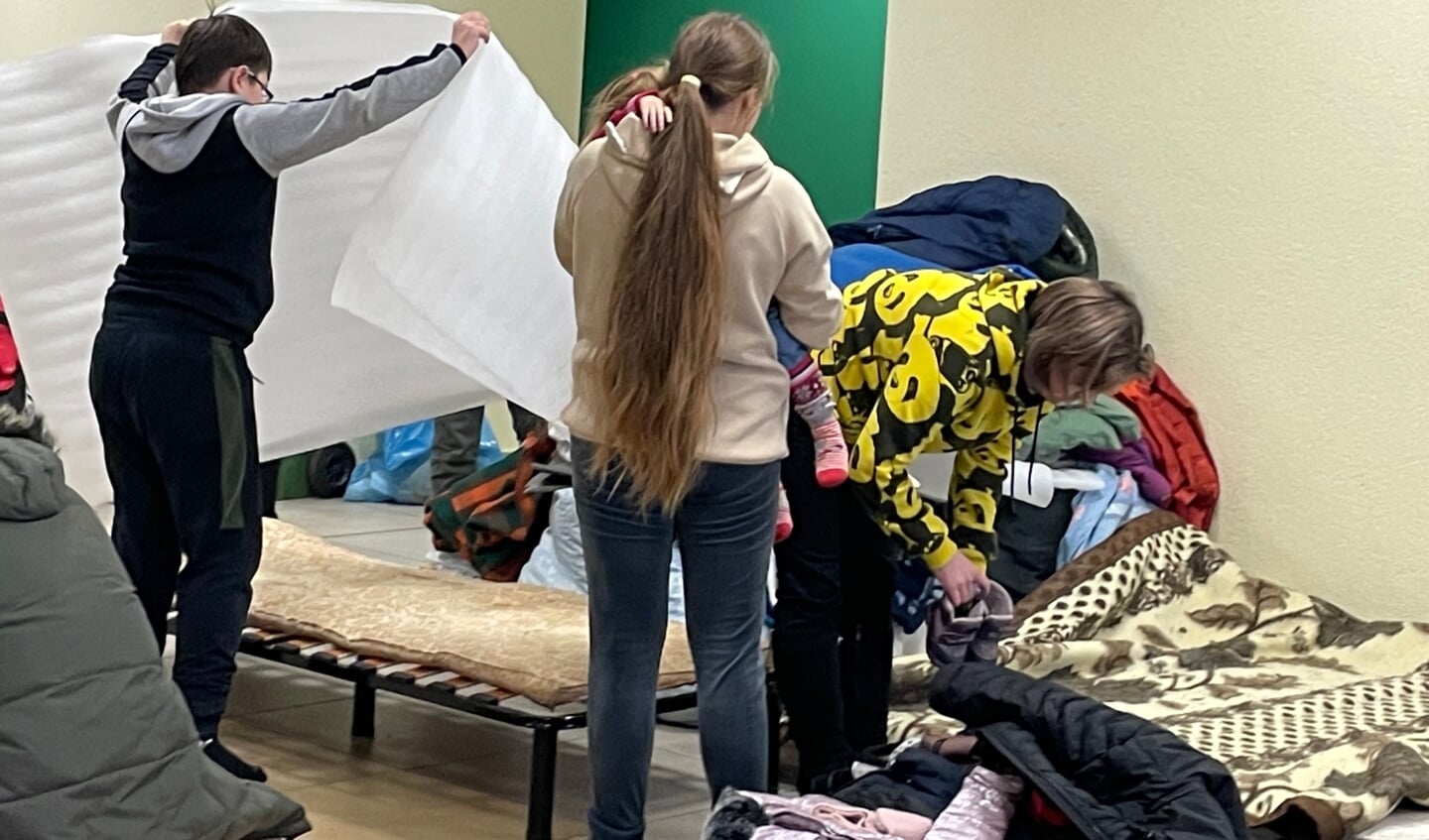 In een zaal van de Arena in Lviv maken vluchtelingen hun slaapplek in orde.