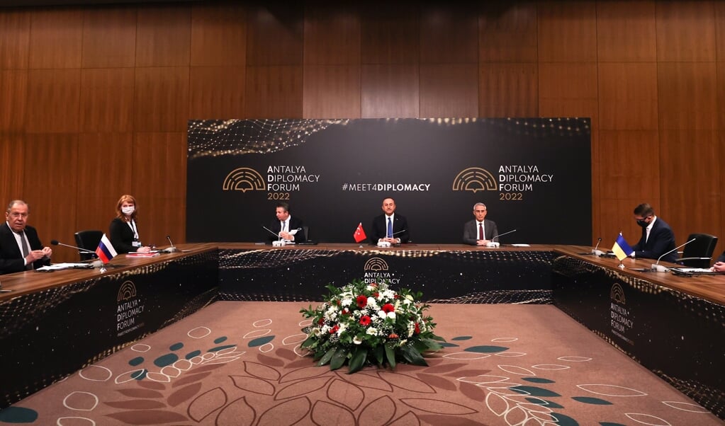 De ministers van Buitenlandse Zaken van Rusland Sergej Lavrov (links) en Oekraïne Dmytro Koeleba (rechts) voor hun besprekingen in het Turkse Antalya. In het midden de Turkse minister Mevlut Cavusoglu die het overleg faciliteerde.   (beeld epa / Cem Ozdel)