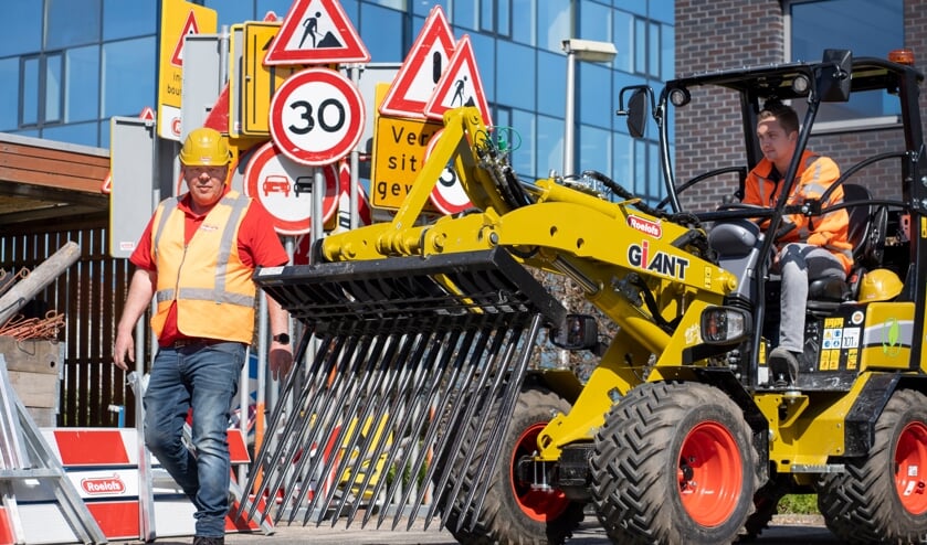 De shovel kan onder meer worden gebruikt om putten en in het wegdek verzonken palen te tillen (links). Met een zogeheten riekbak wordt bestrating uitgegraven (rechts).
