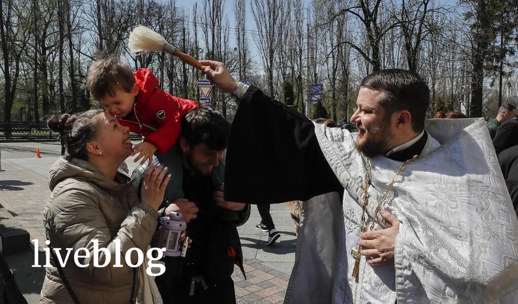 Een priester zegent een gezin tijdens het orthodoxe Pasen afgelopen zondag in de Sint Volodimyr-kathedraal in Kyiv.  (beeld epa / Sergey Dolzhenko)