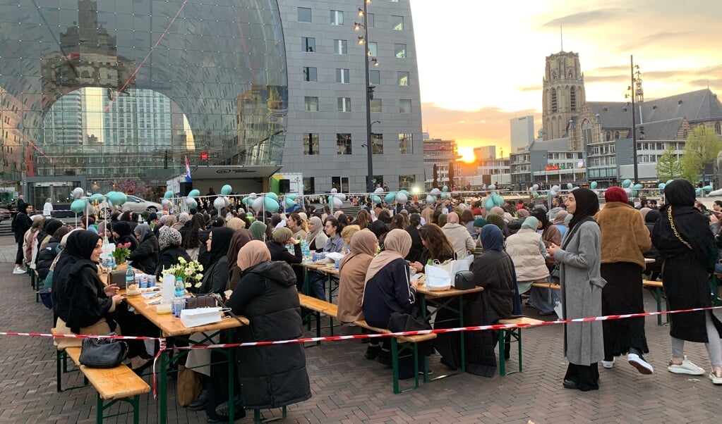 De zon gaat bijna onder en dus kan er over enkele minuten gegeten worden tijdens de Street Iftar in Rotterdam.  (beeld nd)