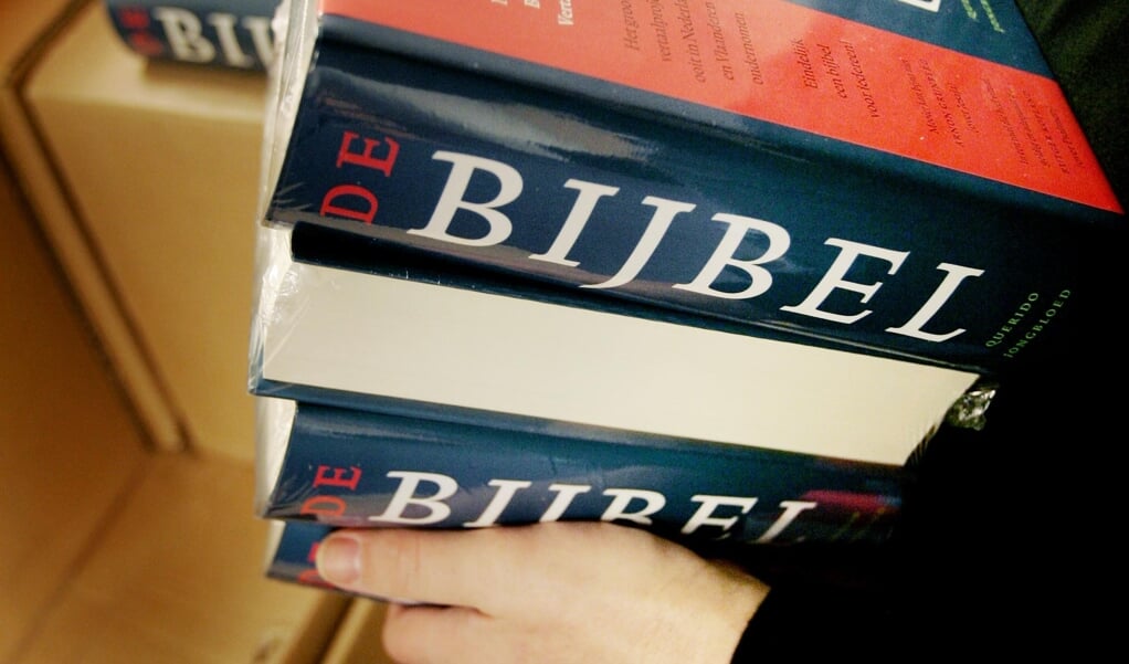Een medewerker van boekhandel Scheltema verplaatst dinsdag een stapel nieuwe bijbels in het magazijn van de winkel in Amsterdam.  (beeld anp Foto/koen Suyk)