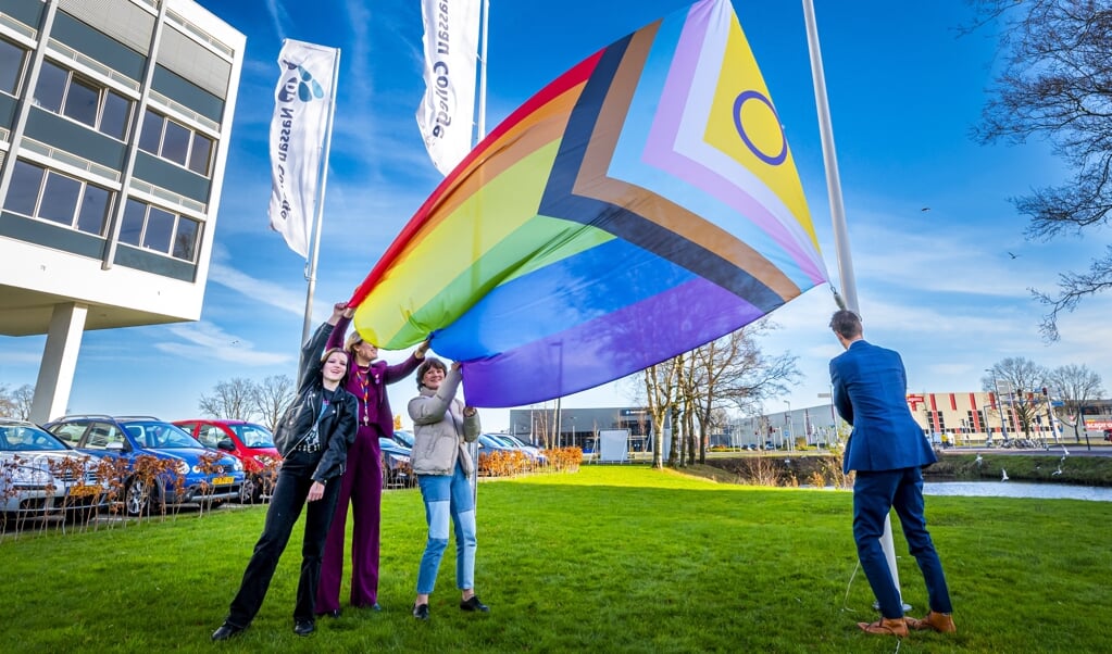 Leerlingen van Nassau College (locatie Penta) in Assen hijsen de regenboogvlag in kader van Paarse Vrijdag.   (beeld anp / Marcel J. de Jong)