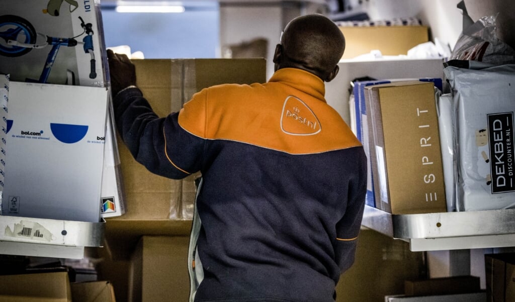 Een pakkettenbezorger van Post NL aan het werk.   (beeld anp / Freek van den Bergh)