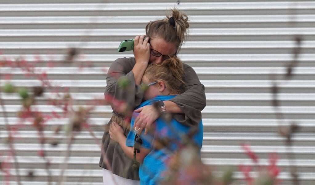 Rouwenden bij een buurthuis in het Texaanse Uvalde, waar een schutter 22 mensen, onder wie 19 kinderen, doodschoot. (beeld afp / Allison Dinner)