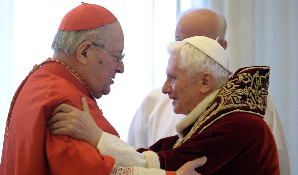 Kardinaal Angelo Sodano (links) groet paus Benedictus XVI toen hij in 2013 zijn aftreden als paus bekend maakte.  (beeld afp / Osservatore Romano)