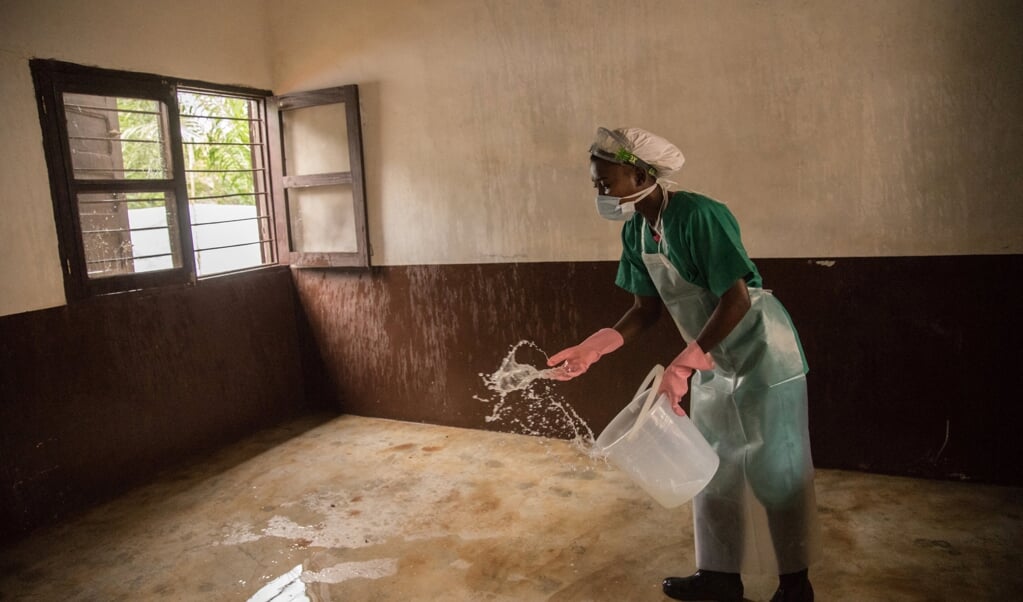 Een man in de Centraal Afrikaanse Republiek desinfecteert de ruimte waar een patiënt met apenpokken is behandeld. In Afrika is het virus niet onbekend, maar nu duikt het ook in westerse landen op.  (beeld afp / Charles Bouessel)