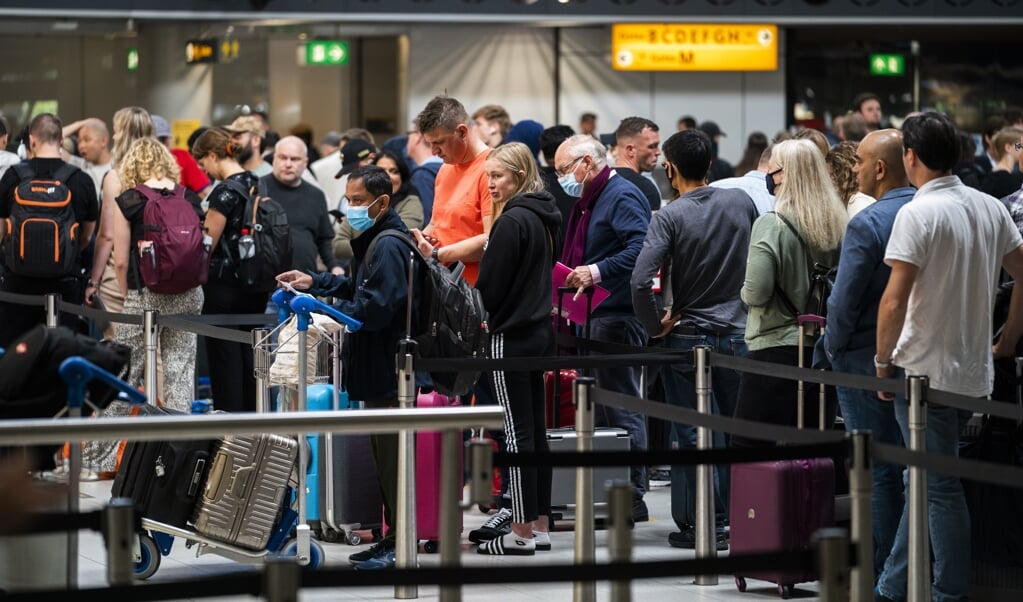 Het is druk in de vertrekhal van luchthaven Schiphol op Hemelvaartsdag. De rijen zijn lang, maar lopen goed door. De meeste vakantiegangers hadden zich voorbereid op de lange wachttijden, die al weken worden veroorzaakt door drukte en personeelstekorten.  (beeld anp / Jeroen Jumelet)