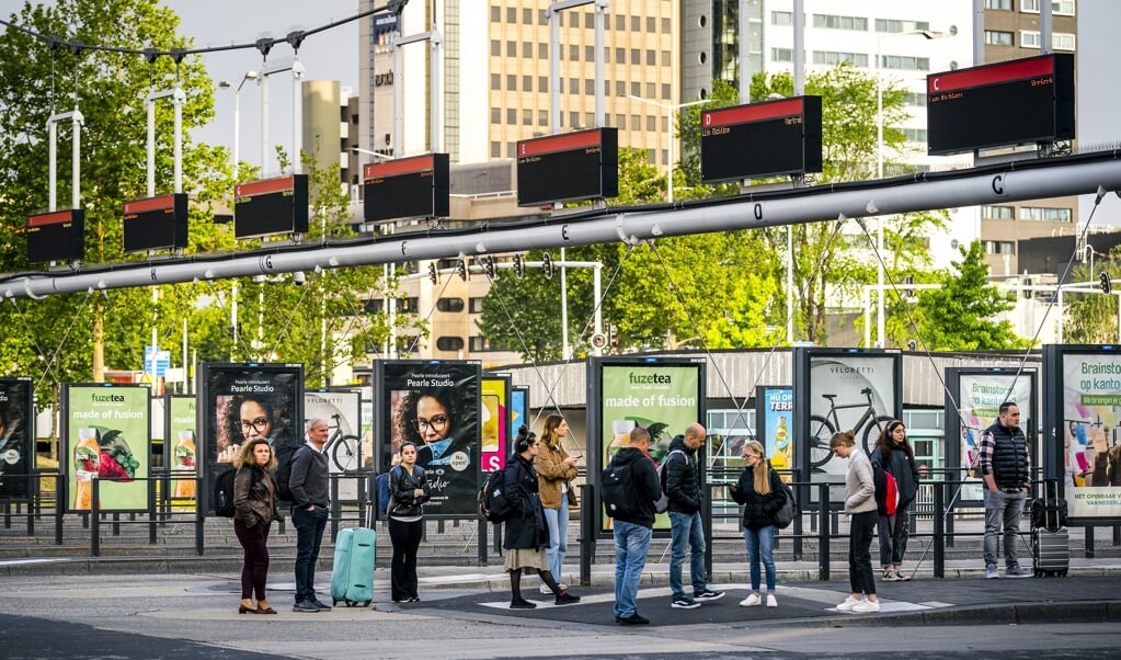 Reizigers wachten tevergeefs op de bus op het busstation van Eindhoven. Buschauffeurs in het streekvervoer staken uit onvrede over het eindbod dat hun werkgevers hebben gedaan in de cao-onderhandelingen.  (beeld anp / Rob Engelaar)