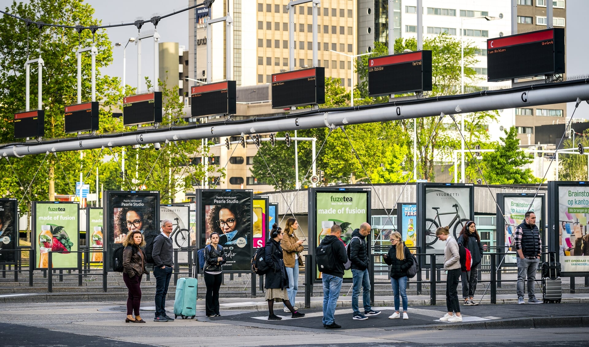 Reizigers wachten tevergeefs op de bus op het busstation van Eindhoven. Buschauffeurs in het streekvervoer staken uit onvrede over het eindbod dat hun werkgevers hebben gedaan in de cao-onderhandelingen.