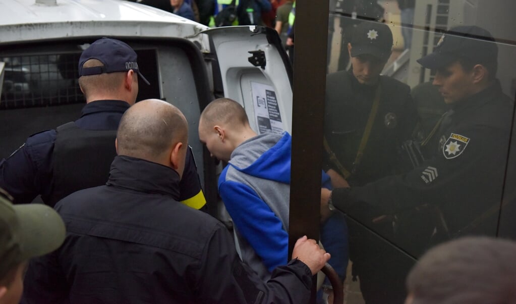 De 21-jarige Russische sergeant Vadim Sjisjimarin wordt door bewakers weggeleid nadat hij door een rechtbank in Kyiv was veroordeeld tot levenslang voor het doden van een Oekraïense burger. (beeld epa / Oleg Petrasyuk)