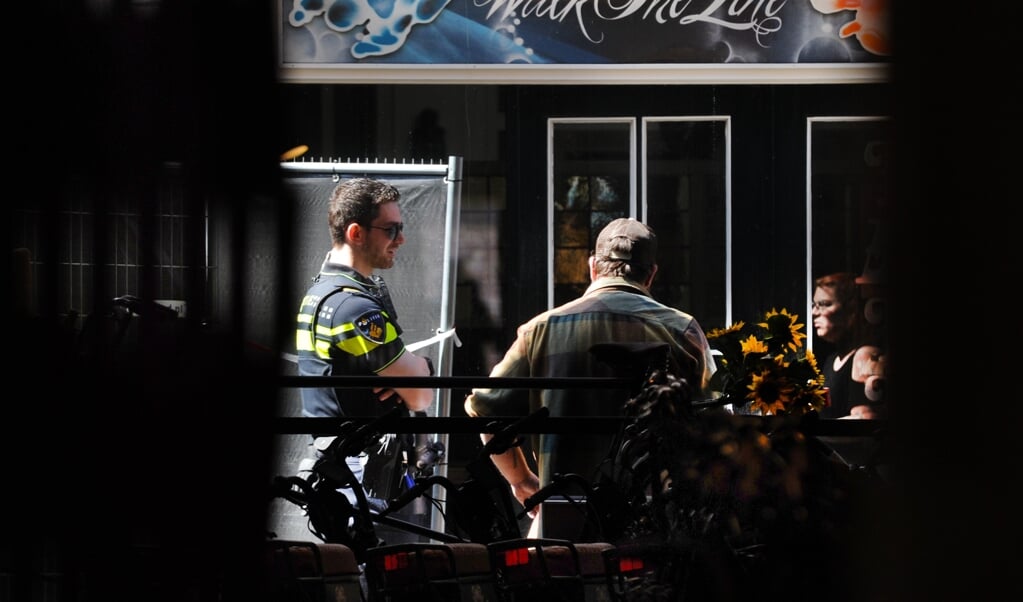 De politie aan het werk in een afgezette Sint Jacobsstraat in Vlissingen. In de schoenwinkel werd woensdagavond het lichaam gevonden van winkeleigenaar Johan Quist. (beeld Lex de Meester)