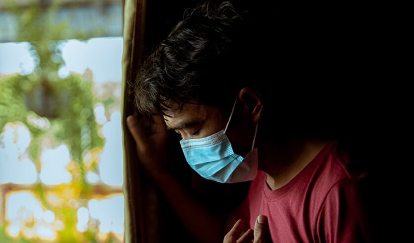 Een man met mondmasker heeft moeite met ademhalen. Hij heeft last van bijwerkingen na COVID-19 gehad te hebben.  (beeld Getty Images/iStockphoto)