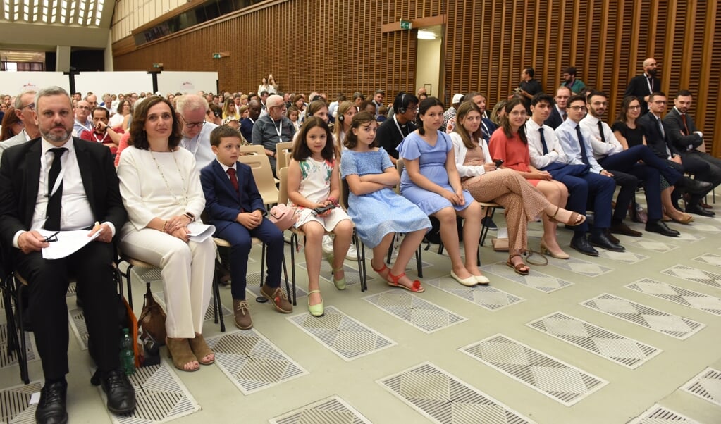 Massimo en Patrizia Galosi en hun twaalf kinderen op de eerste rij in de Paulus VI-aula in het Vaticaan. (beeld Paolo Galosi)