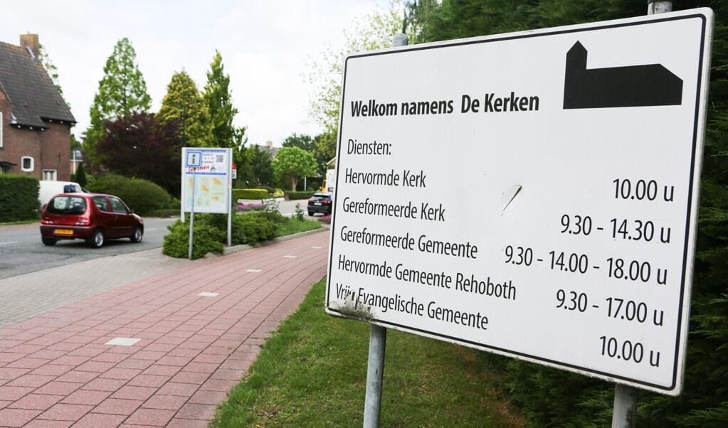 Een bord aan de rand van het dorp heet bezoekers welkom namens vijf kerken.  (beeld Maarten Boersema)