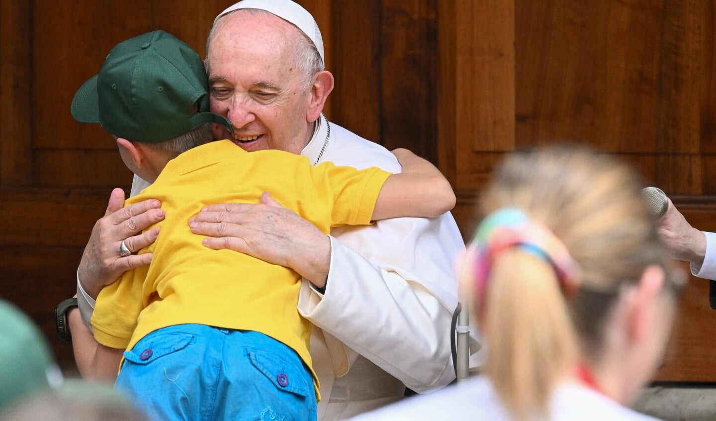 Paus Franciscus omhelsde een Oekraïens kind tijdens een ontmoeting met kinderen op 4 juni 2022.