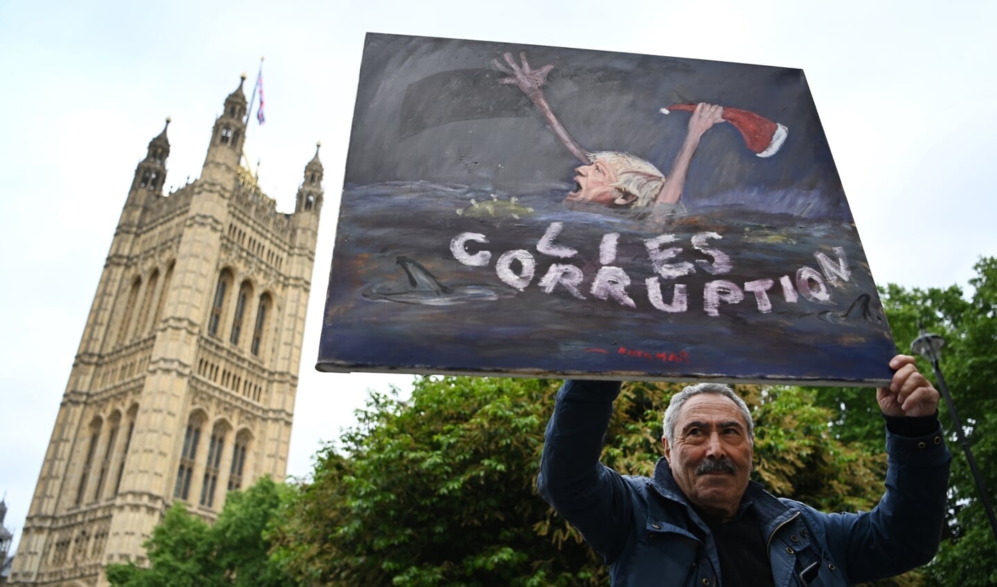 Een Brit demonstreert bij de parlementsgebouwen in Londen tegen Boris Johnson: ‘leugens en corruptie’.