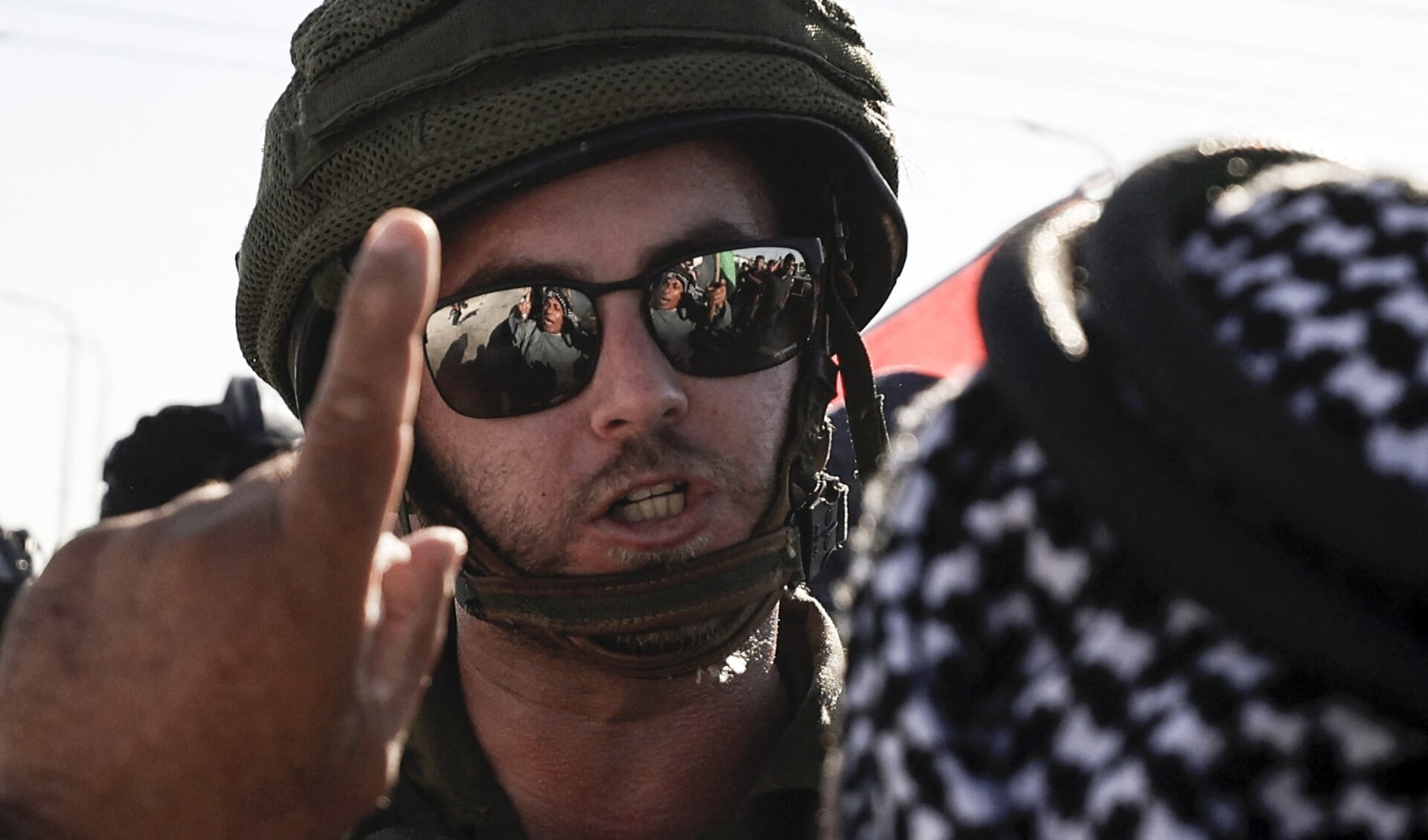 Een Palestijn discussieert met een Israëlische soldaat op de West Bank.