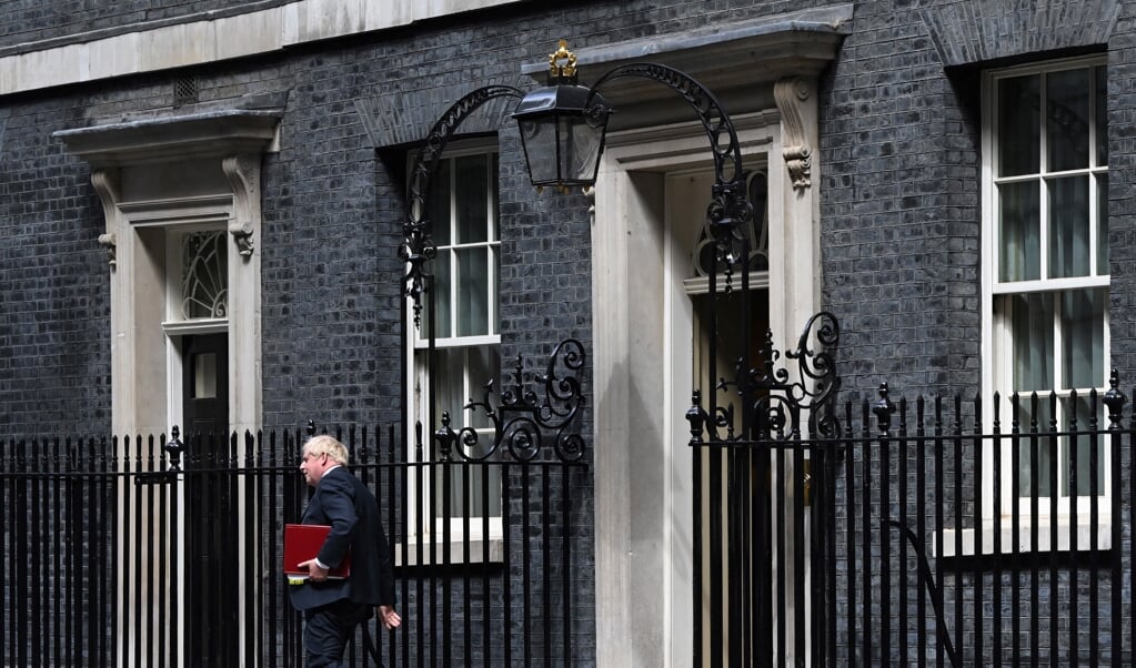 Johnson verlaat 10 Downing Street in Londen om in het parlement vragen te beantwoorden. (beeld afp / Justin Tallis)