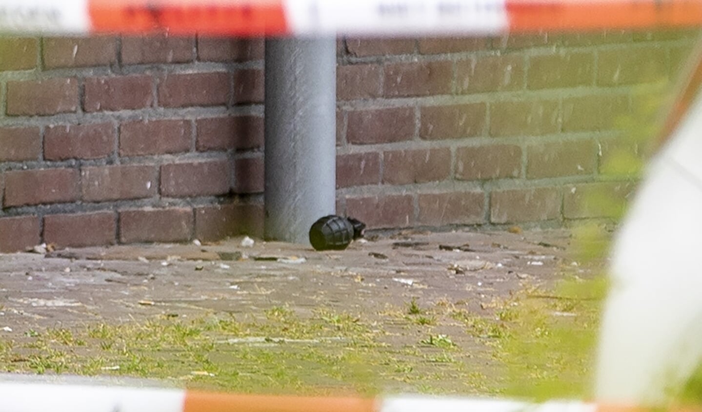 Een handgranaat ligt op straat bij een wooncomplex.