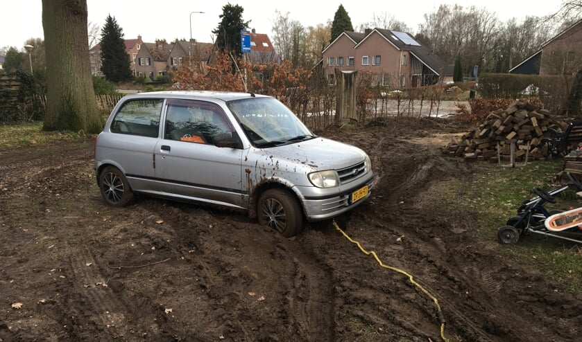 De auto zit vast in de modder.