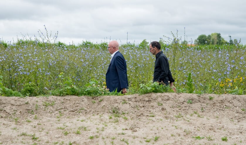 Landbouwminister Henk Staghouwer (links) wordt rondgeleid door akkerbouwer Joost van Strien.