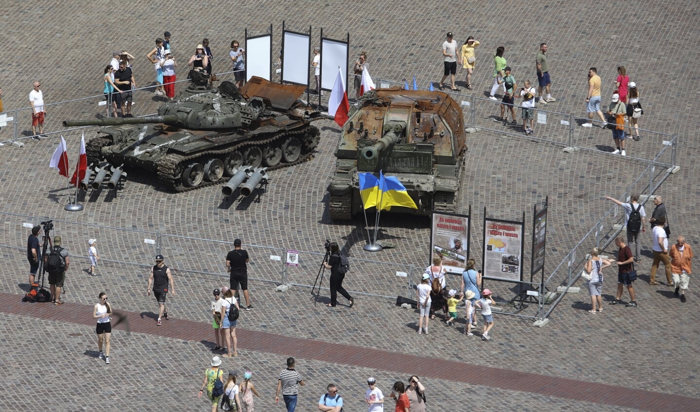 Toeristen lopen langs het vernietigde Russische oorlogstuig dat tentoongesteld staat in het centrum van Warschau.