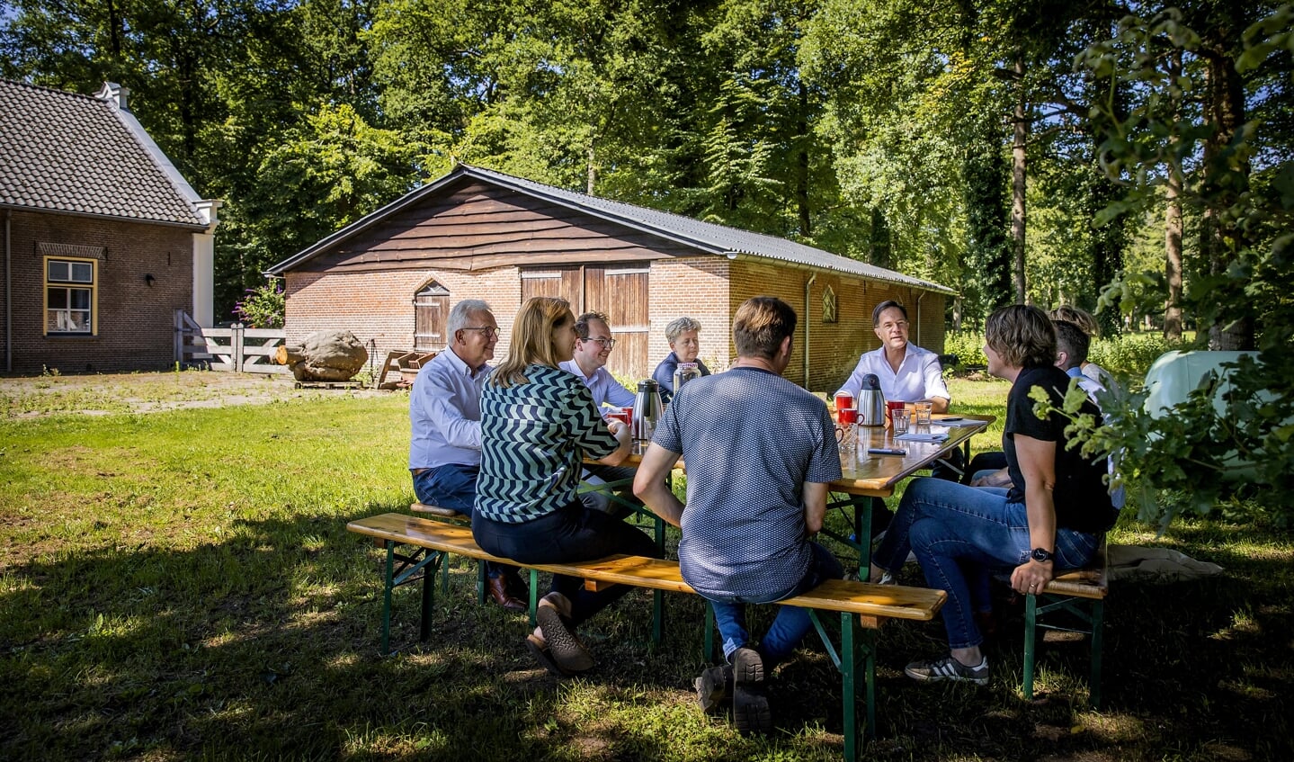 Premier Mark Rutte spreekt met boeren over de stikstofplannen tijdens een bezoek aan een boerderij.