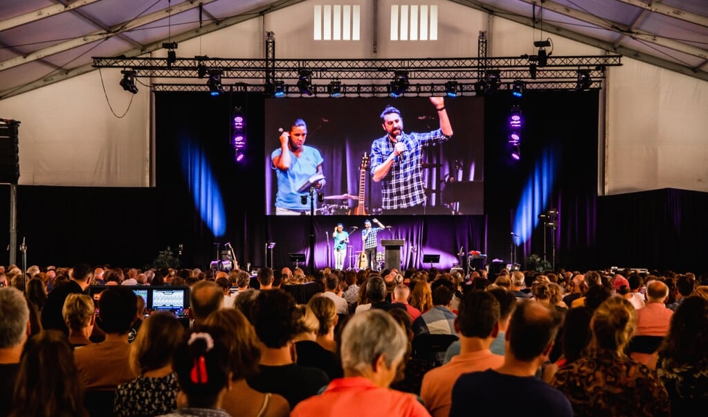 De Britse spreker Tim Hughes vertelt aan een volle zaal over geestelijke strijd in denken. (beeld Judith Arendsen-Fokker)