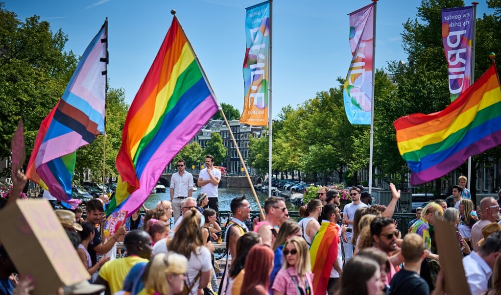 Deelnemers aan de Pride Walk lopen door Amsterdam op de eerste dag van Pride Amsterdam. Na de coronacrisis is het negendaagse evenement terug als vanouds. (beeld anp / Phil Nijhuis)