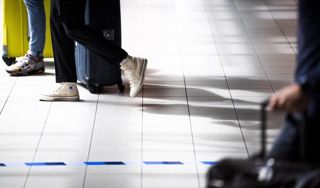 Reizigers op Schiphol. Met een vliegtaks van bijvoorbeeld 100 euro worden alternatieven interessanter. (beeld anp / Freek van den Bergh)