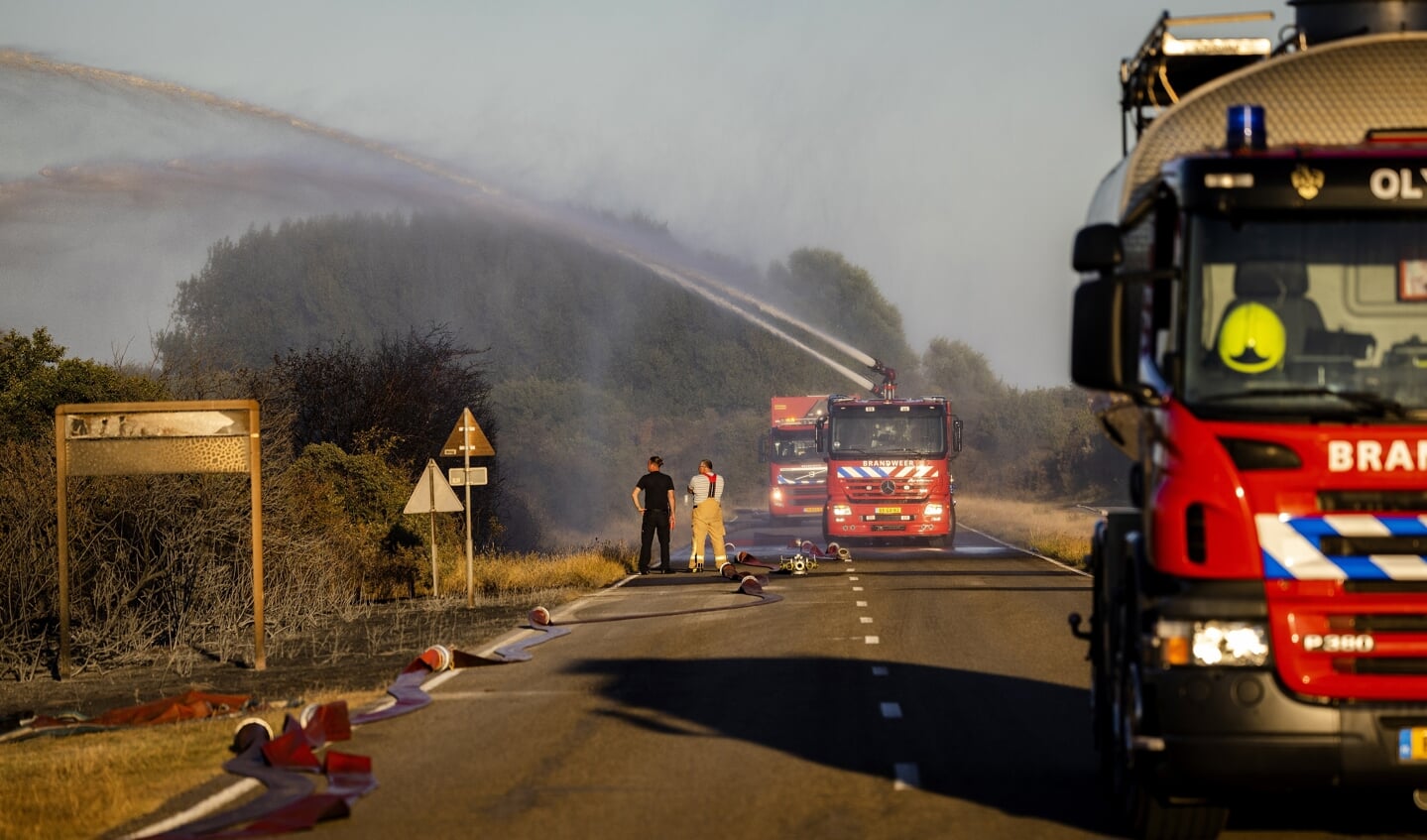 Brandweerlieden proberen een brand te bestrijden in het duingebied bij de Brouwersdam. 