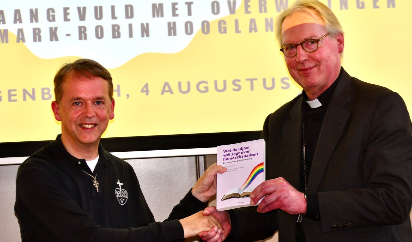 Mark-Robin Hoogland overhandigt zijn vertaling van 'Wat de Bijbel wél zegt over homoseksualiteit' aan bisschop Gerard de Korte.