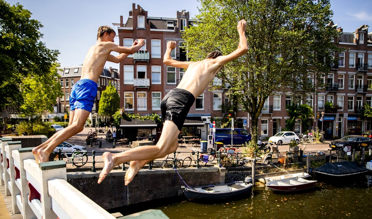 Gemeenten gaan strenger handhaven op wildzwemmen. Verkoeling zoeken in een gracht, zoals de jongens op de foto, kan binnenkort waarschijnlijk niet meer