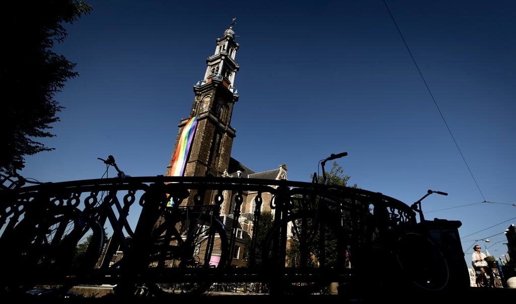 De regenboogvlag wappert op de Westertoren in Amsterdam in aanloop naar de Canal Pride 2018. (beeld anp / Koen van Weel)