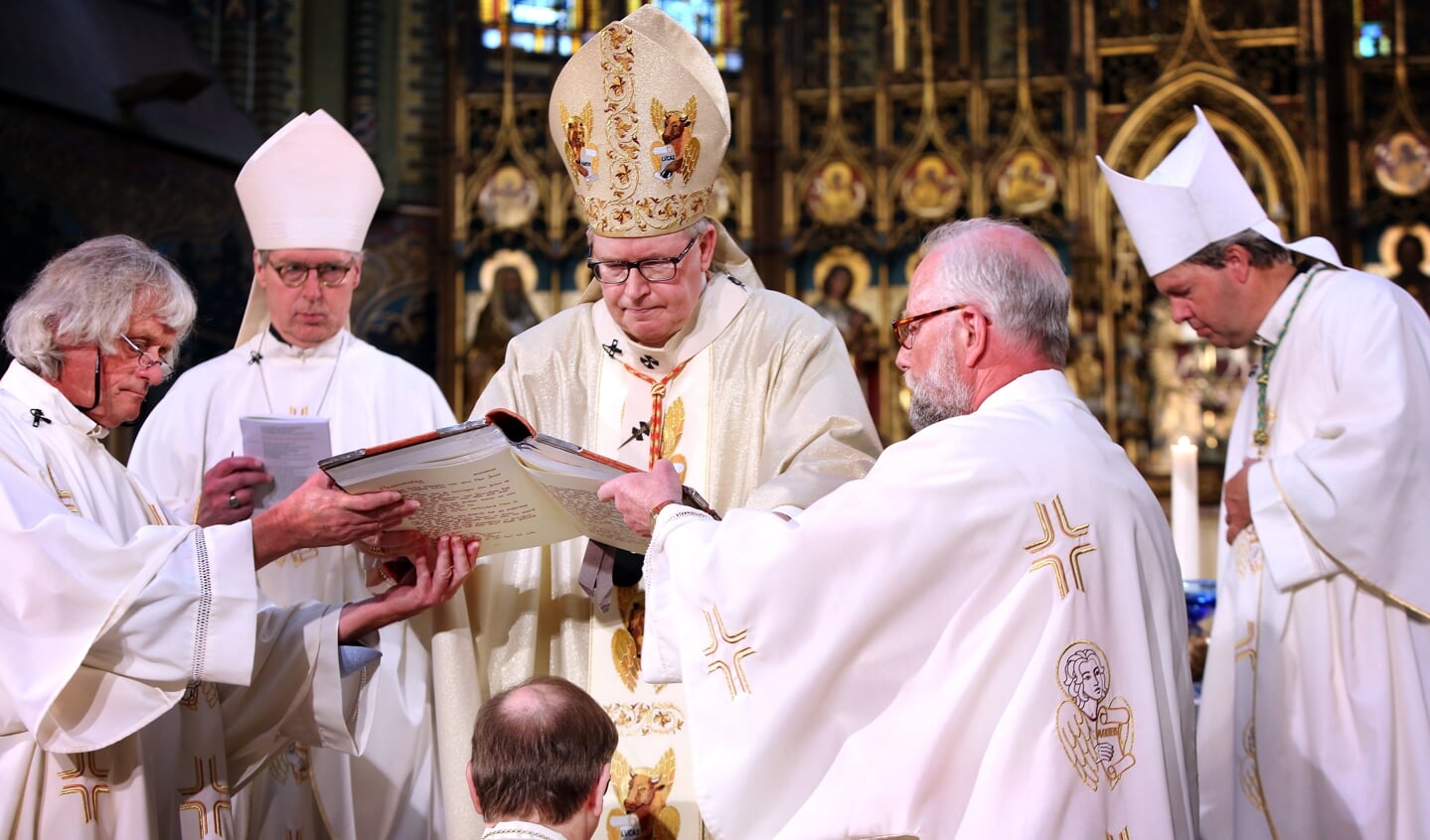 Kardinaal Wim Eijk (midden) met de bisschoppen Gerard de Korte (links) en Rob Mutsaerts (rechts) bij de wijding van bisschop Ron van den Hout (midden, onder) in 2017. 