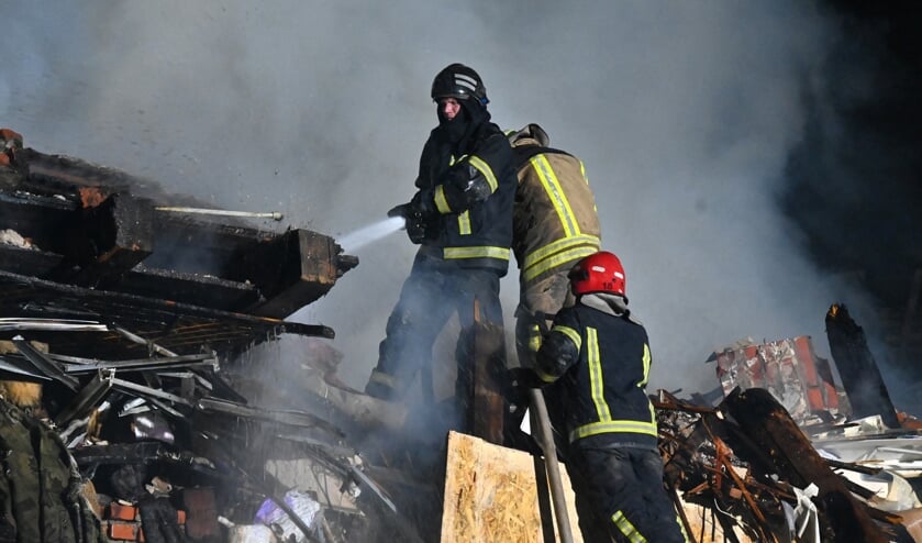 Brandweerlieden blussen een brand op de plaats van een verwoest hostel als gevolg van een raketaanval in Charkov.  (beeld Sergey Bobok / afp)