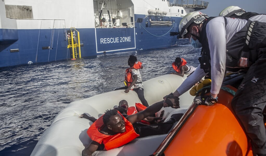 Medewerkers van Artsen zonder Grenzen helpen bootvluchtelingen aan boord van het reddingsschip Geo Barents. (beeld Médecins Sans Frontières)