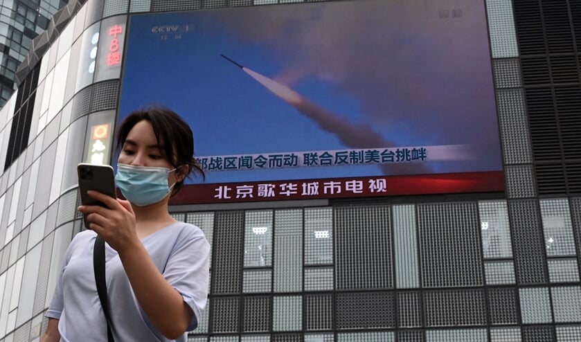 Een scherm in Peking met informatie over de 'militaire oefening'.  (beeld afp / Noel Celis)