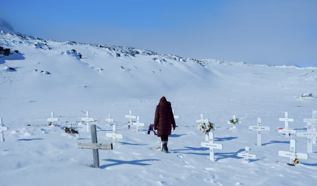 The acclaimed artist Shuvinai Ashoona visits the local cemetery in Kinngait, Nunavut, Canada, on April 6, 2022.  Near the Arctic Circle, Shuvinai Ashoona, a star of the Venice Biennale, and a multi-generational community of Inuit artists refuse to let isolation stand in their way. (Brendan Ko/The New York Times)  (beeld anp)