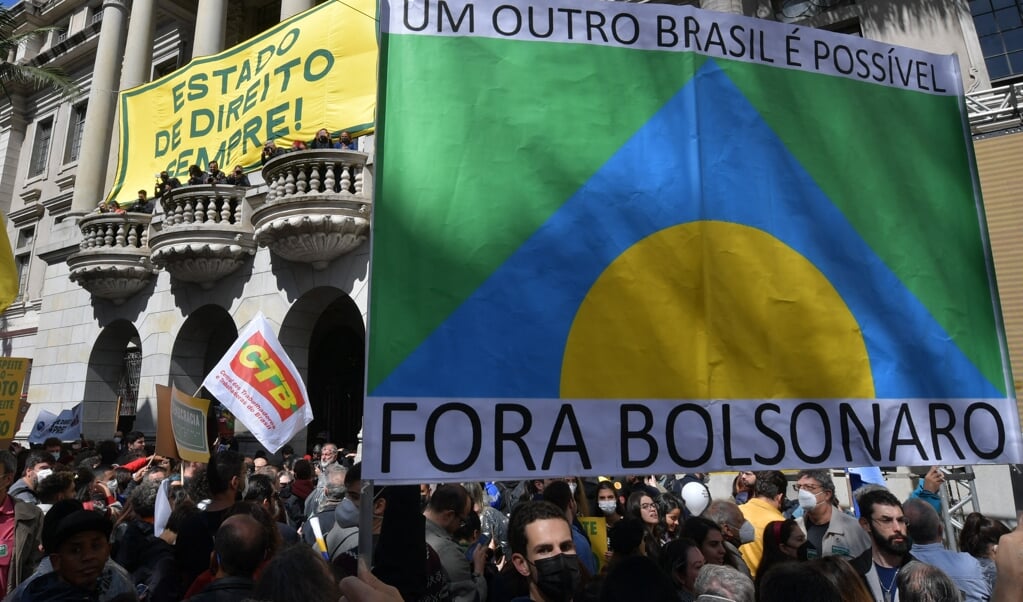 Demonstranten in São Paulo donderdag dragen een spandoek met de tekst: 'Weg met Bolsonaro'.  (beeld afp / Nelson Almeida)