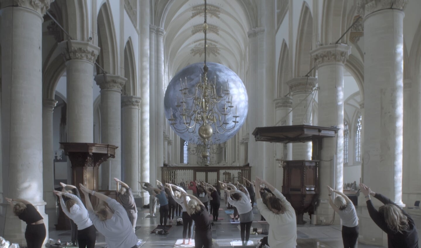 Beeld van een yogales in de Grote Kerk van Breda uit de documentaire van Machiel van Hoek.