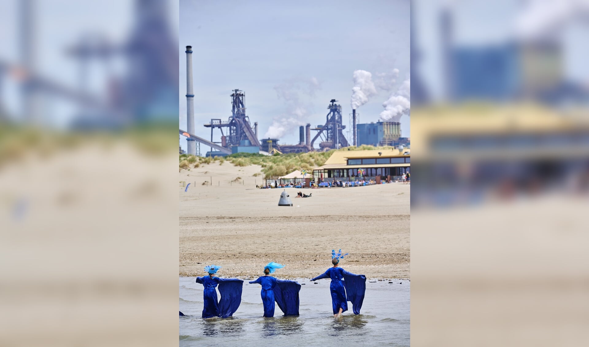 Klimaatactivisten verbeelden de luchtverontreiniging en stijging van de zeespiegel, tegen het decor van de Tata Steel-staalfabriek. 