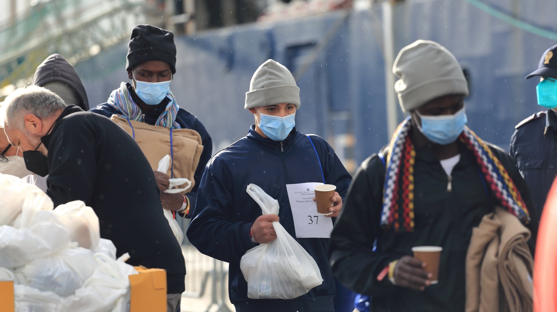 Asielzoekers ontvangen drinken en een deken in de haven van Salerno, Italië, na dagenlang verblijf op een reddingsschip van Artsen zonder Grenzen. 