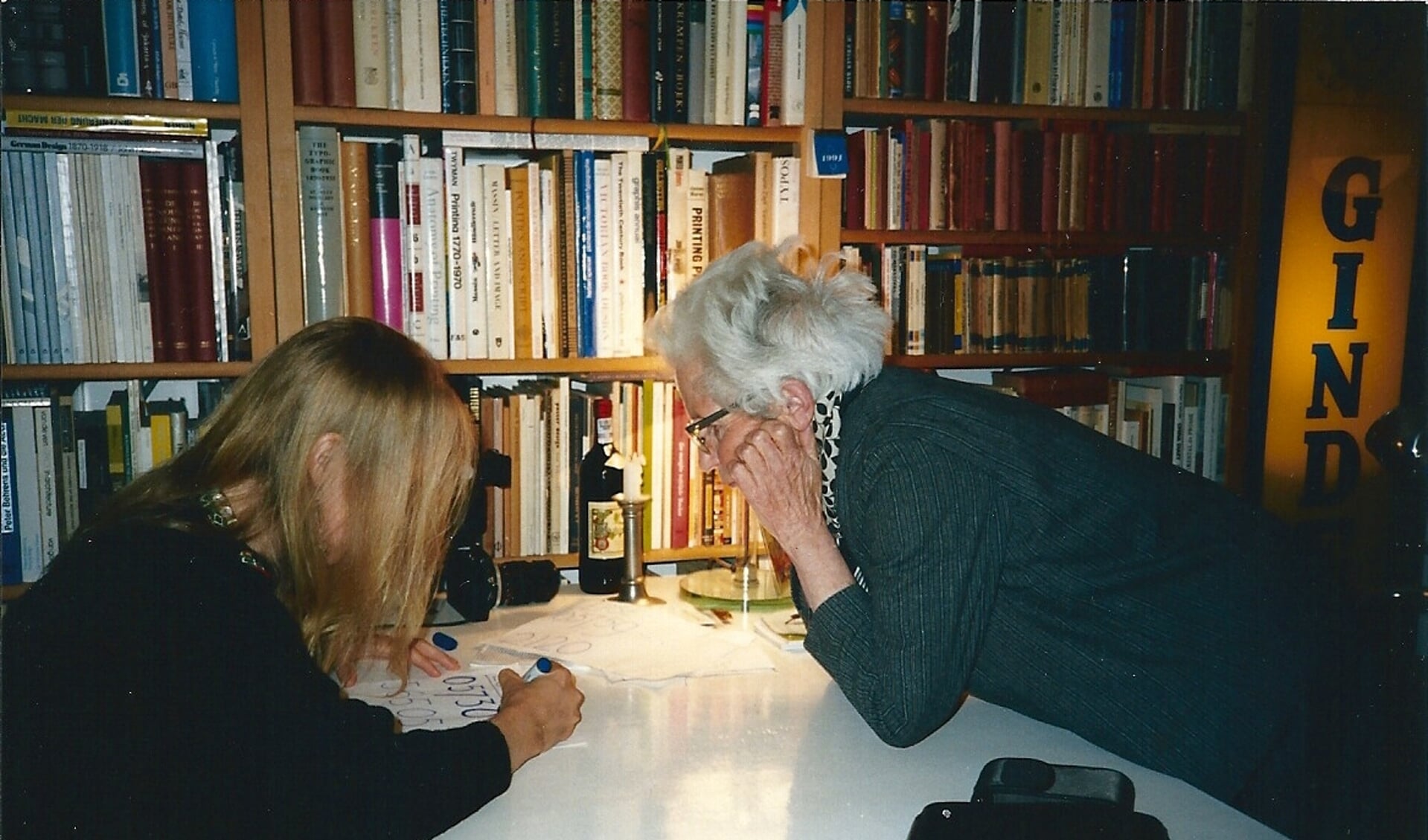 Pieta van Beek (links) schrijft voor de bijna blinde Ida Gerhardt een telefoonnummer in grote letters.