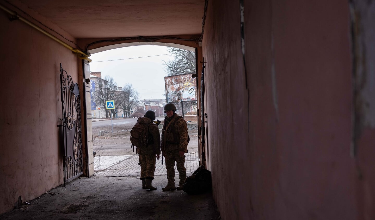 Twee soldaten zoeken dekking in de poort in het westen van Bachmoet.