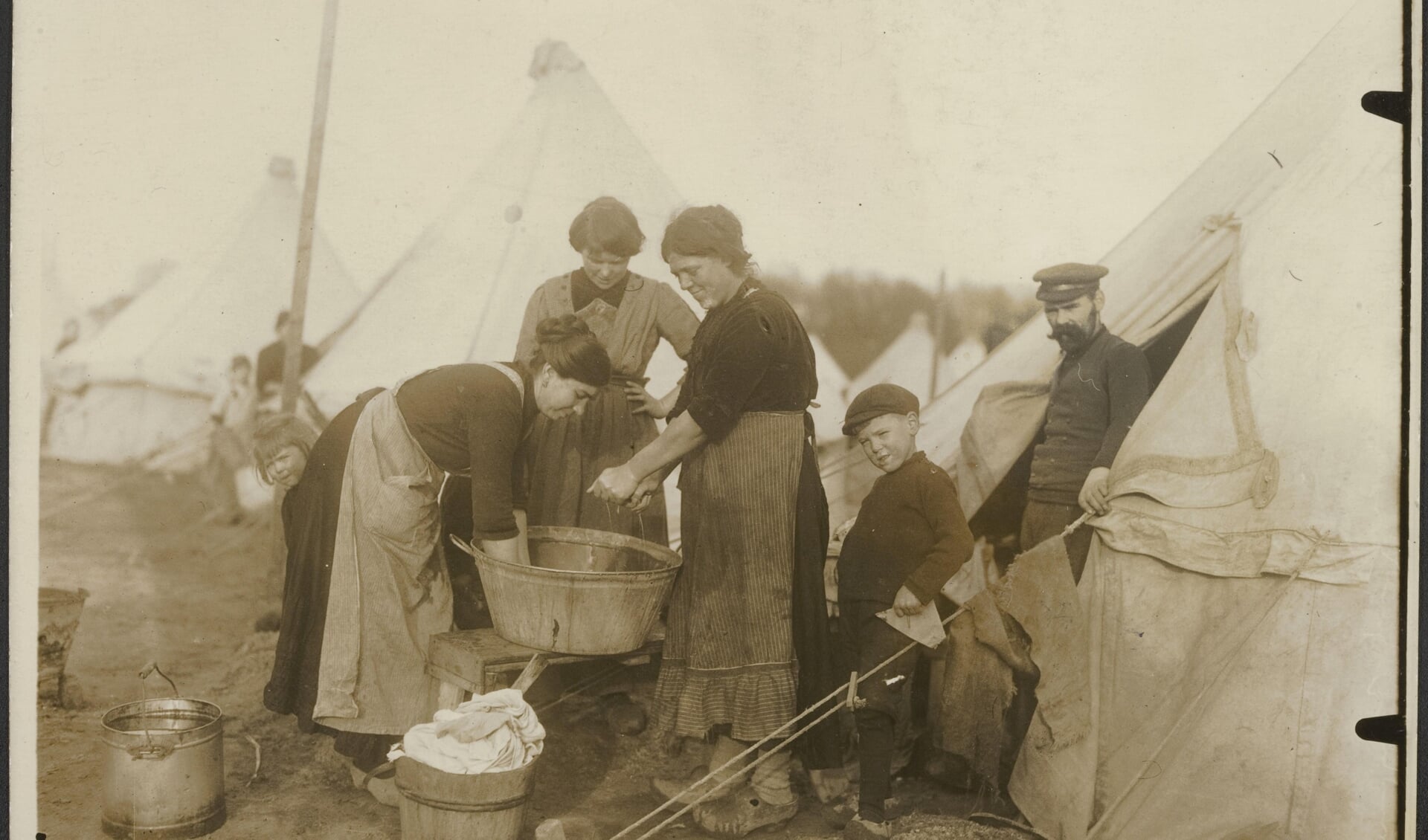 Belgische vluchtelingen doen in 1914 de was in een tentenkamp in Nederland.