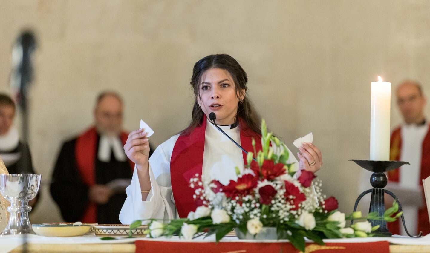 Sally Azar gaat voor in de viering van het Heilig Avondmaal in de dienst waarin zij geordineerd werd als predikant in de Lutherse Kerk van de Verlosser in de oude stad van Jeruzalem. 